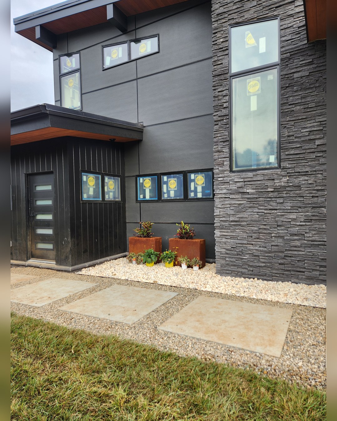 Stacked stone, cedar soffit and a paver walk to the entry