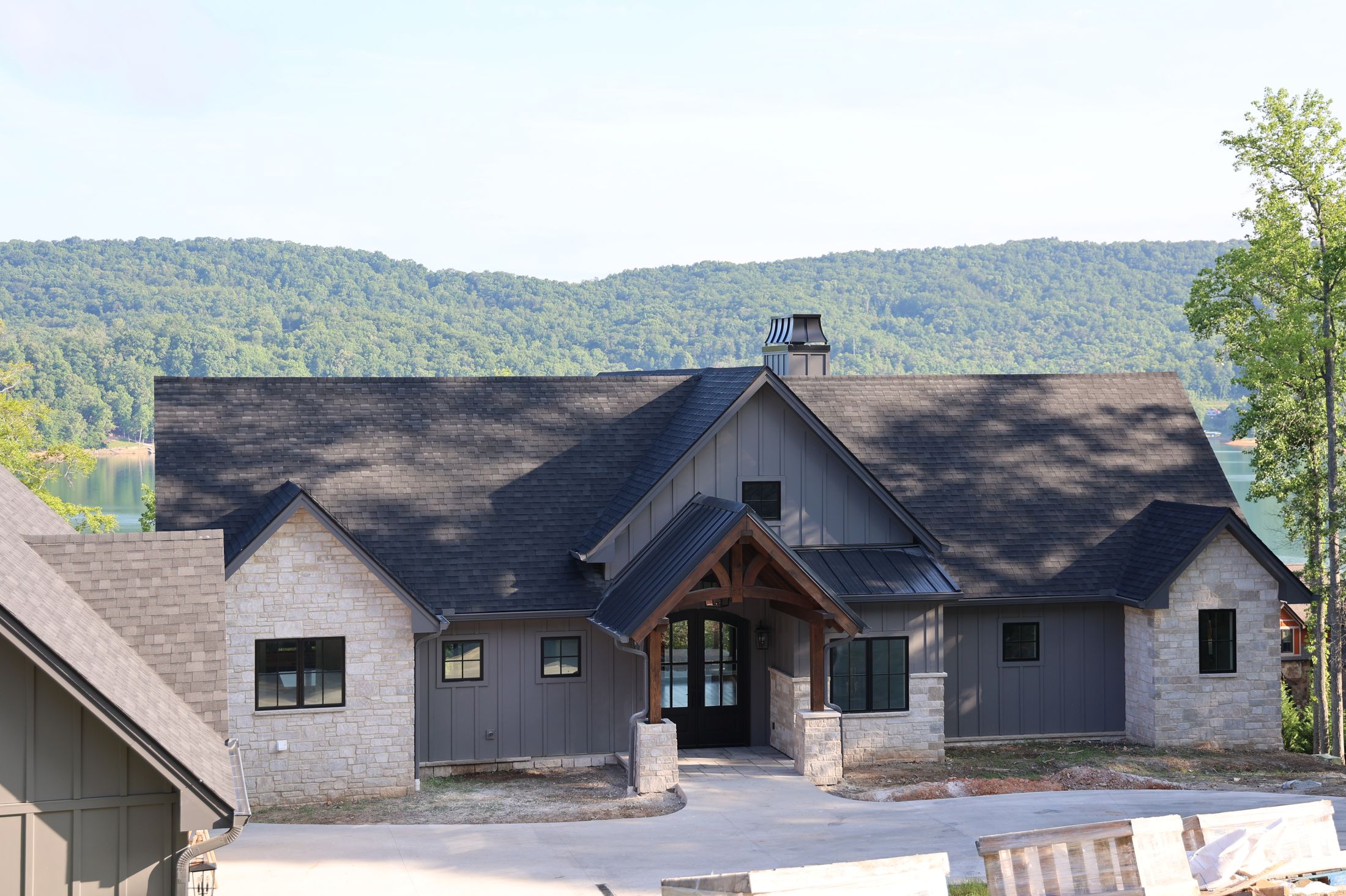 Finished custom home with shake siding, stone and a timber entry