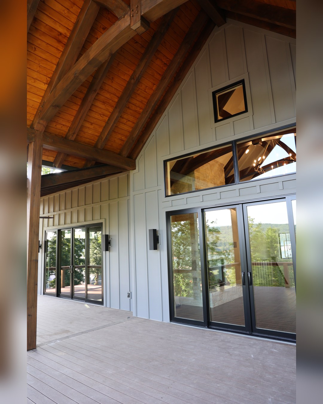 Board-and-batten exterior with timber brackets and a wall of glass to the ridge
