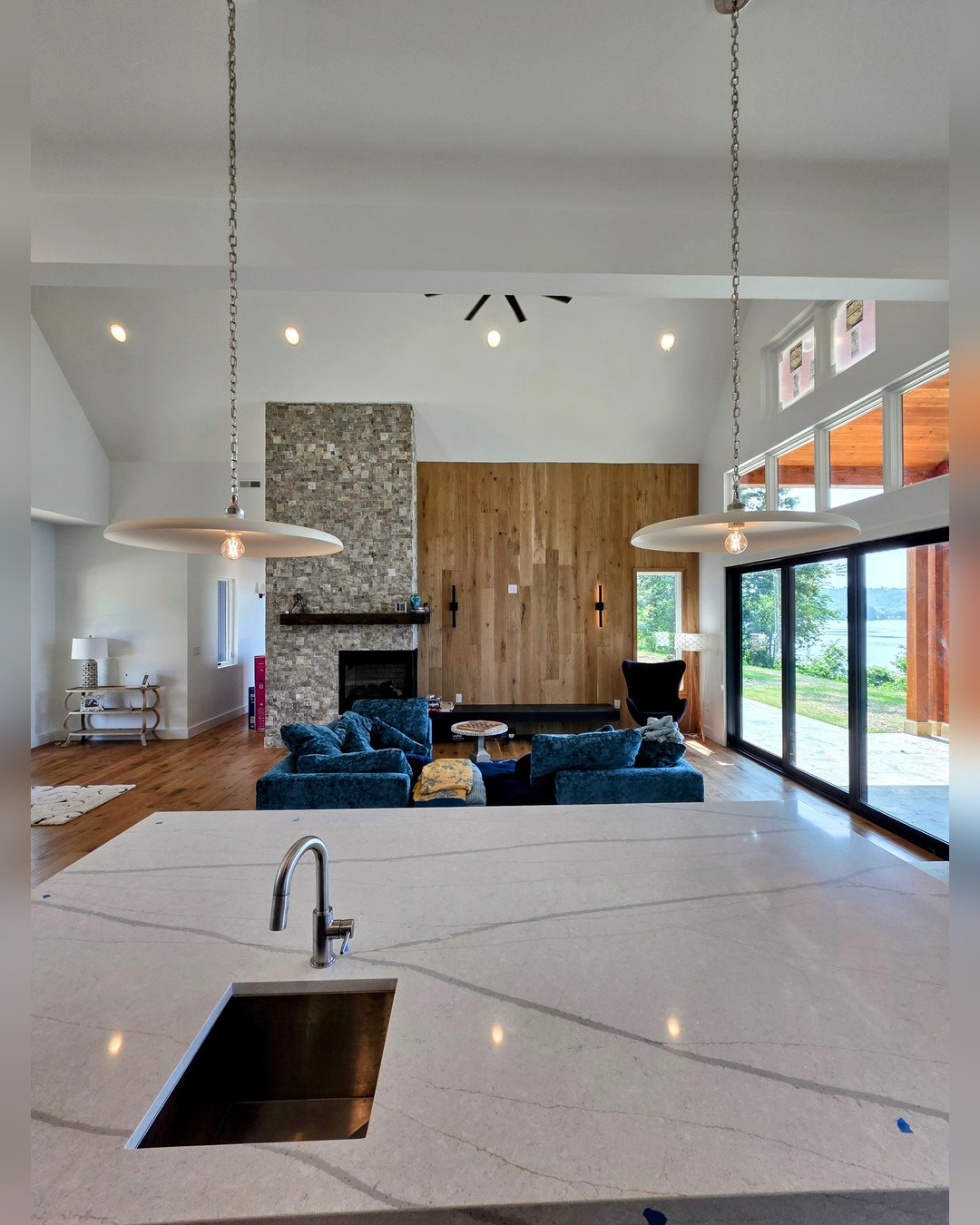 Open plan living with a fireplace and glass along the lake side